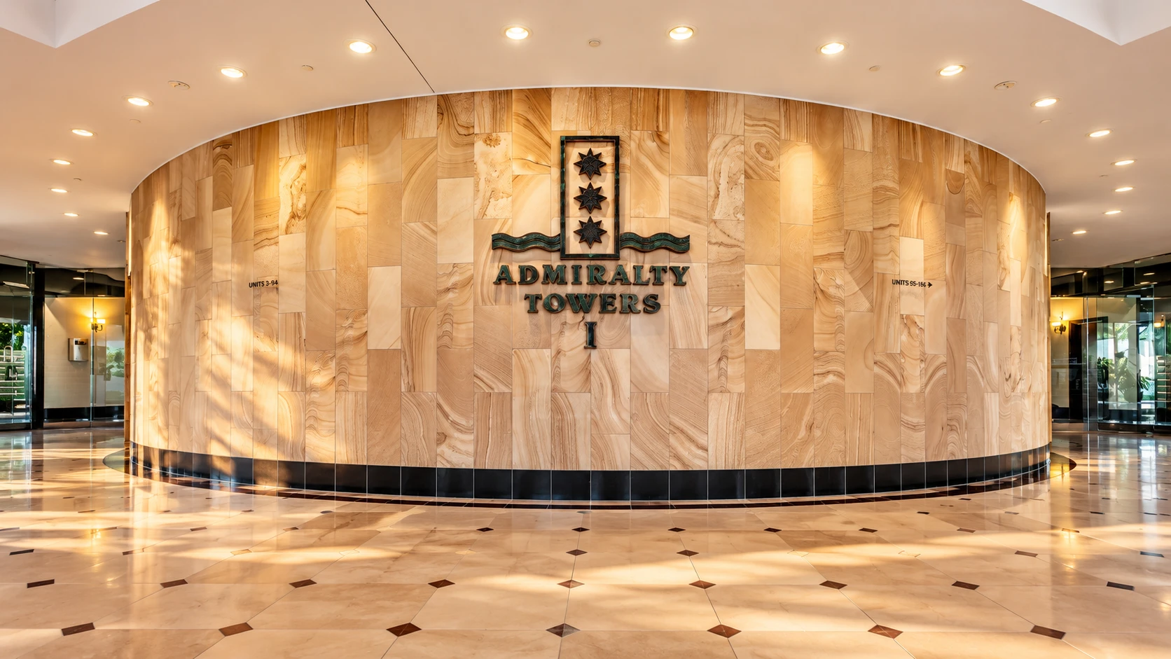 Sandstone entrance wall with the Admiralty Towers I bronze signage